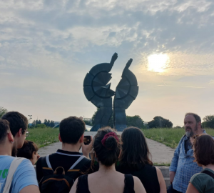 Heykel önünde toplanmış bir grup insanın olduğu fotoğraf